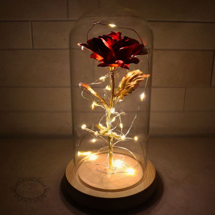Eeuwige gouden roos met sfeervolle LED-verlichting onder een elegante glazen stolp, perfect cadeau.