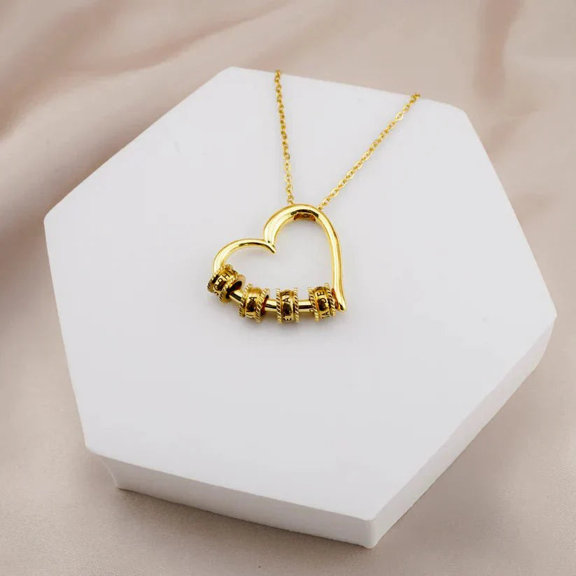Hartvormige ketting voor moeder met gegraveerde namen, verguld roestvrij staal, gepresenteerd in luxe verpakking.