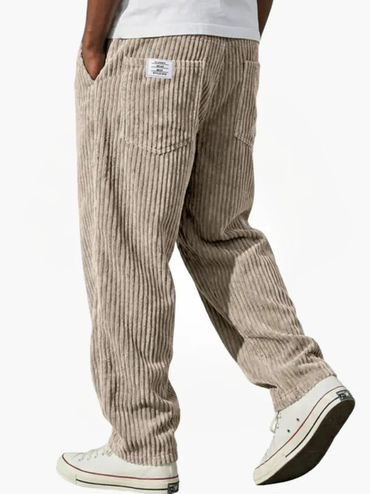 Zachte corduroy textuur van een blauwe herenbroek, loose fit. Elastische tailleband en trekkoord voor optimaal comfort.