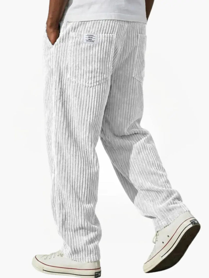 Zijaanzicht van een casual bruine loose fit corduroy herenbroek. Benadrukt de comfortabele en relaxte pasvorm.
