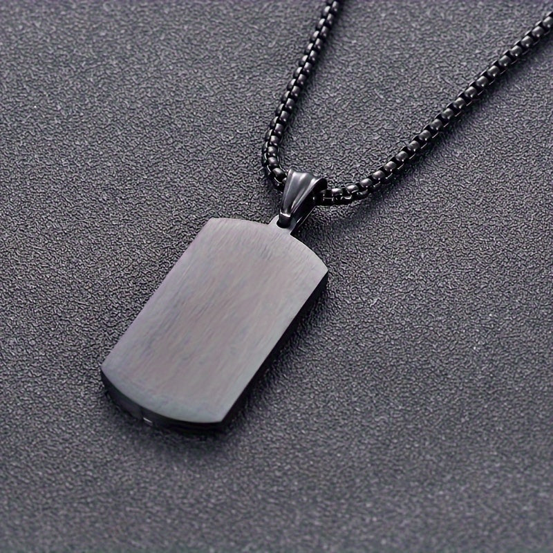 Herenketting met zwarte vintage roestvrijstalen hanger gedragen door man, stoer en modieus heren sieraad.