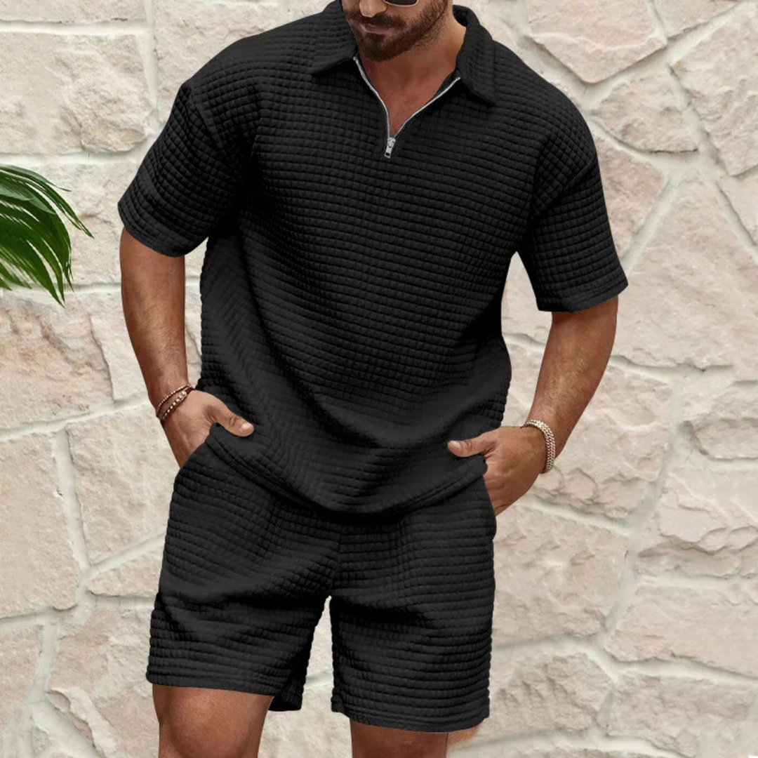 Model draagt een casual heren polo shorts set. Een moderne 2-delige zomerse outfit voor relaxte herenkleding.