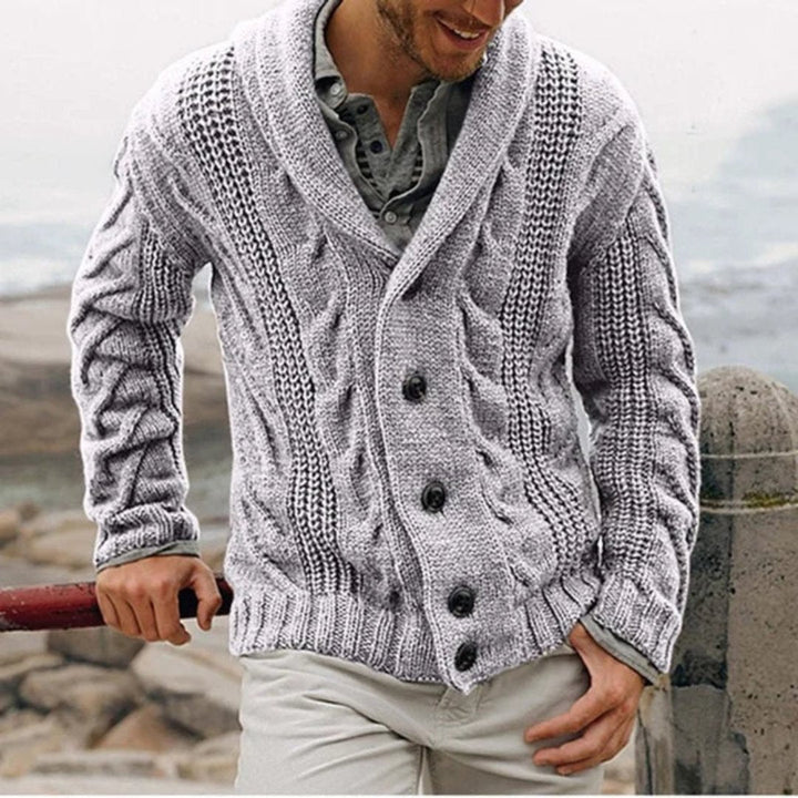 Man draagt modieus gebreid herenvest met shawlkraag, ideaal voor een warme, gelaagde look.