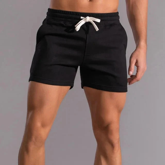 Man draagt comfortabele heren zomer shorts met trekkoord, perfect voor een relaxte dag of actieve momenten.