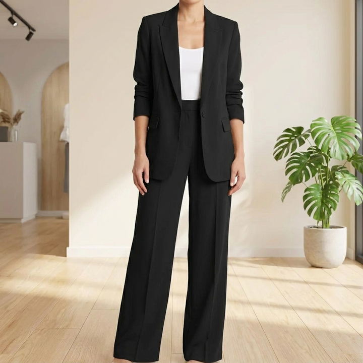 Elegant roze dames tweedelig pak met blazer en broek, perfect voor zakelijke of formele gelegenheden.