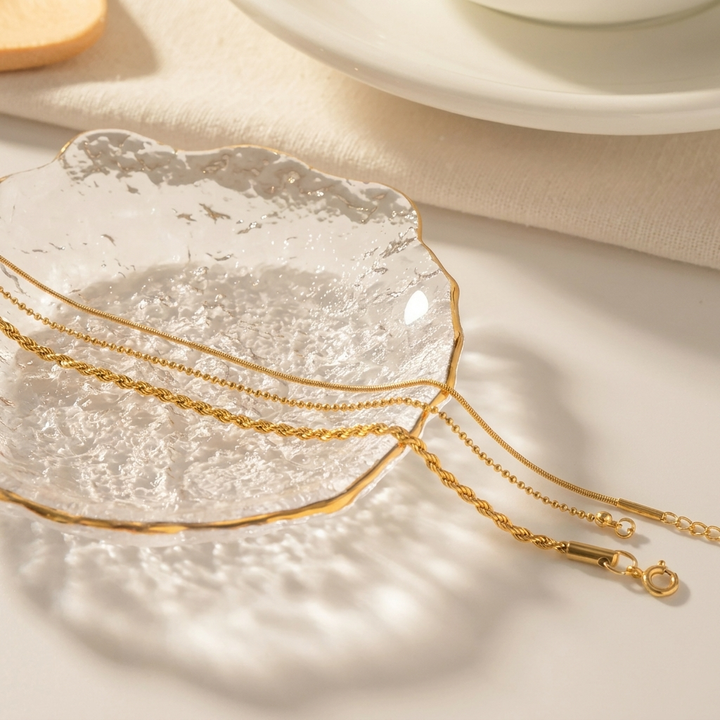 Stijlvolle dames gouden armbandenset met drie gelaagde armbanden. Elegante en modieuze sieraden.