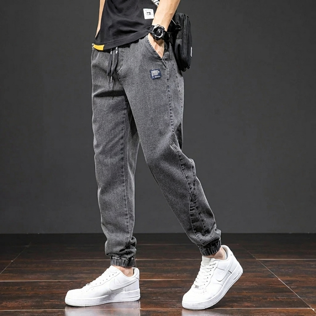 Man draagt een comfortabele heren denim joggingbroek met moderne pasvorm, ideaal voor casual stijl en dagelijkse flexibiliteit.