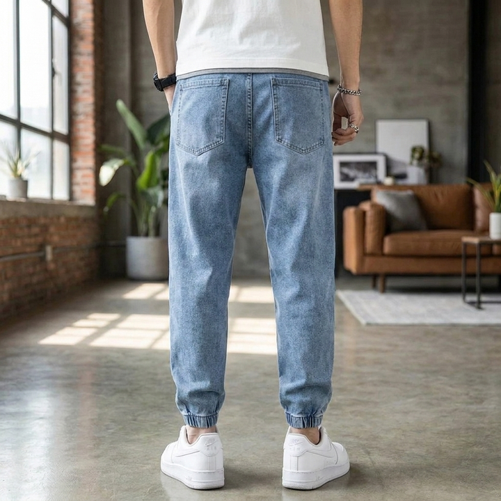 Close-up van de zachte denim stof van deze heren jogger spijkerbroek, met focus op de comfortabele stretch en tailleband.