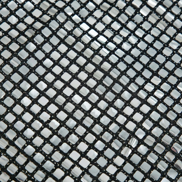 Close-up van de sprankelende glitterstof van een zilveren dames minirok, ideaal als feestrok.