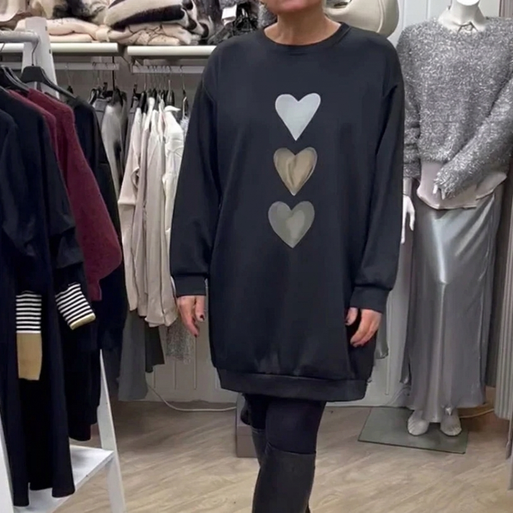 Zwarte oversized dames sweatshirtjurk met lange mouwen en speelse hartprint, ideaal voor casual comfort.