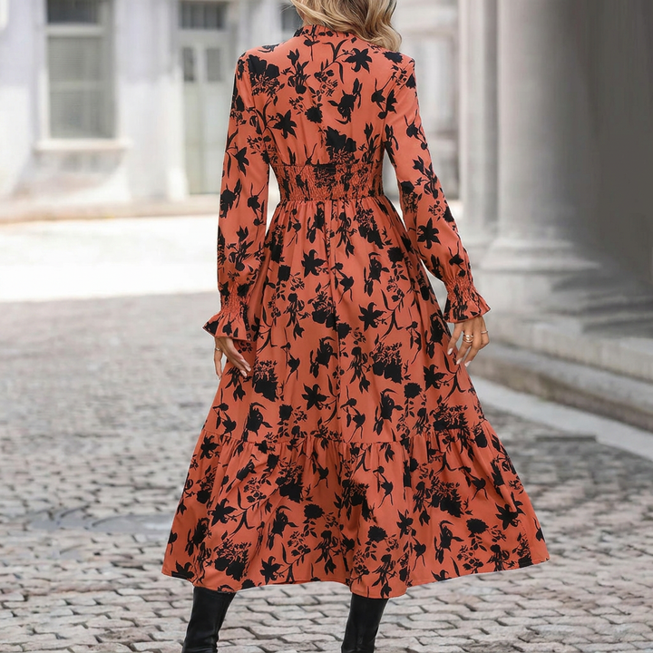 Oranje A-lijn damesjurk met kleurrijke print en V-hals, ideaal als zomerjurk of casual vrouwenkleding.