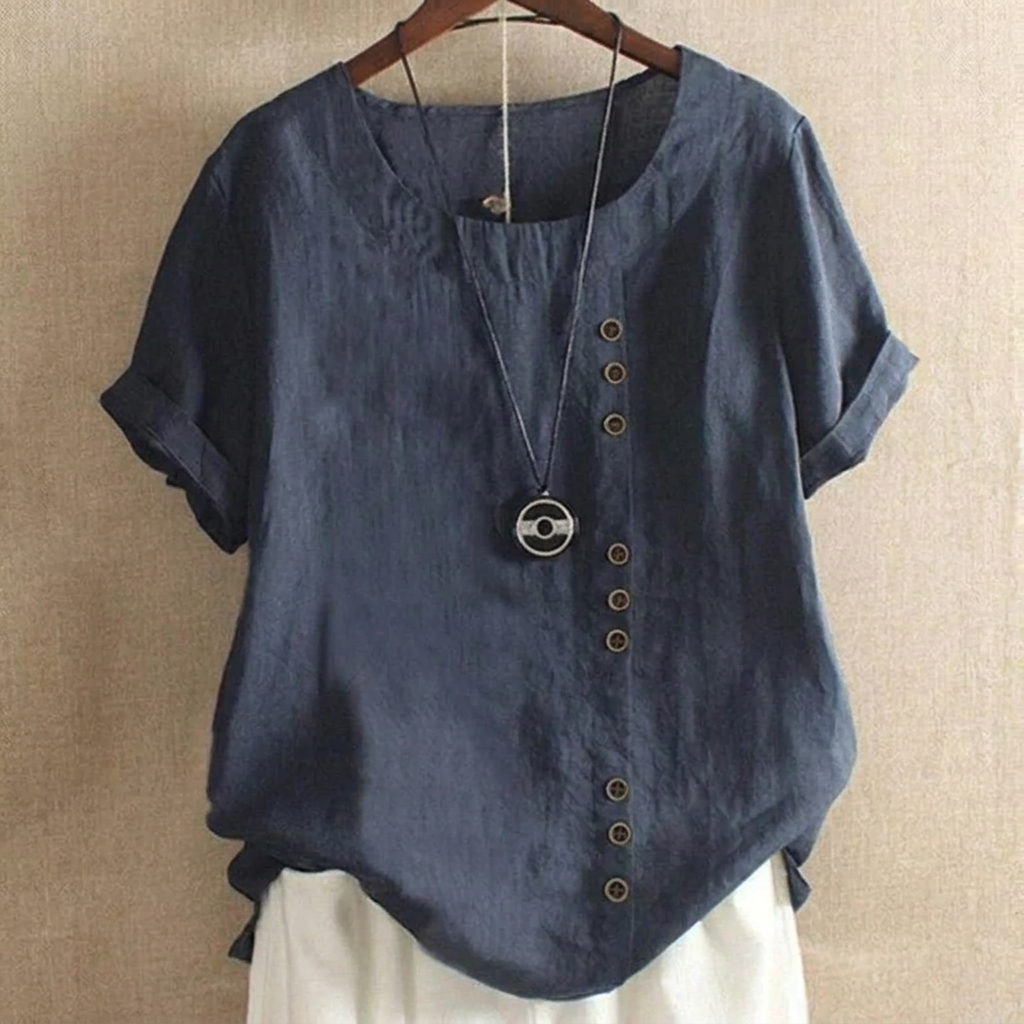 Model draagt stijlvolle dames top met korte mouwen en knoopdetails. Casual-chic look, comfortabel voor elke dag.