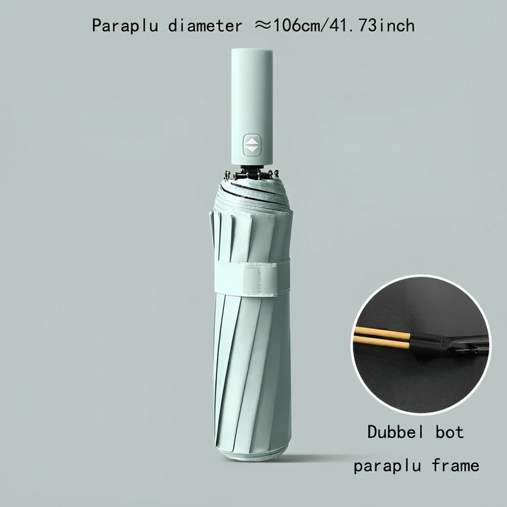 Kleine, weerbestendige paraplu voor reizen, opgevouwen naast een telefoon; toont compactheid.