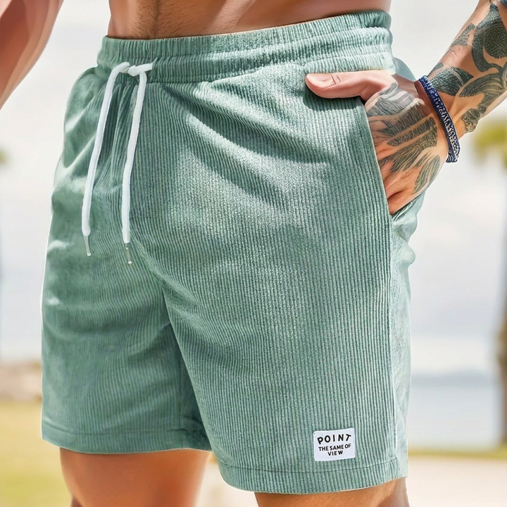 Man draagt comfortabele heren corduroy korte broek met trekkoord; klaar voor zomerse dagen.
