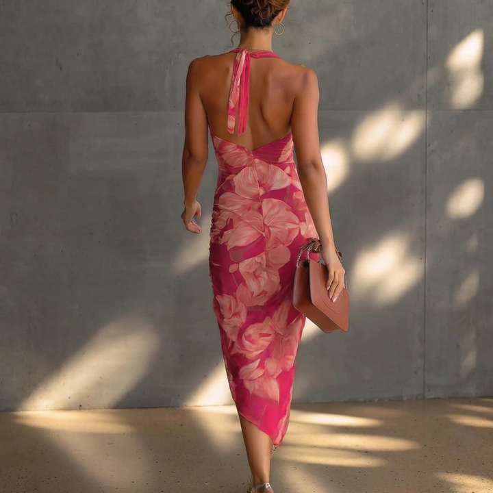 Detailopname van rood-roze geplooide dames midi-jurk met bloemenprint en de elegante watervalhals.