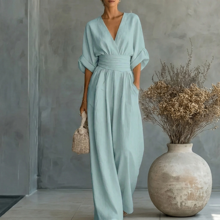 Getailleerde dames jumpsuit met diepe V-hals en vloeiende wijde pijpen, voor een chique en moderne uitstraling.