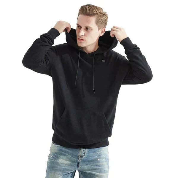 Persoon draagt grijze ThermaHoodie, de verwarmde uniseks hoodie, tijdens een winterwandeling voor extra warmte.