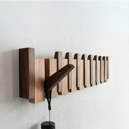 "Houten kapstok met pianotoets design, gemaakt van duurzaam walnoot- en beukenhout, voorzien van meerdere haken."