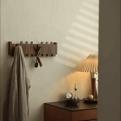 "Houten kapstok met pianotoets design, gemaakt van duurzaam walnoot- en beukenhout, voorzien van meerdere haken."