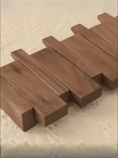"Houten kapstok met pianotoets design, gemaakt van duurzaam walnoot- en beukenhout, voorzien van meerdere haken."