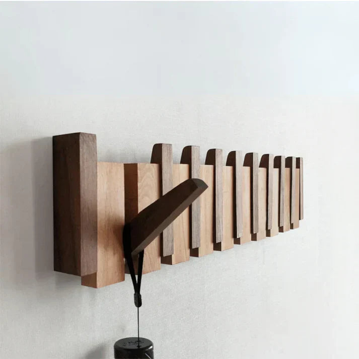 "Houten kapstok met pianotoets design, gemaakt van duurzaam walnoot- en beukenhout, voorzien van meerdere haken."