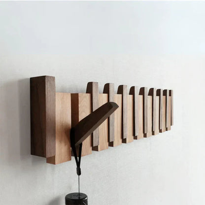 "Houten kapstok met pianotoets design, gemaakt van duurzaam walnoot- en beukenhout, voorzien van meerdere haken."