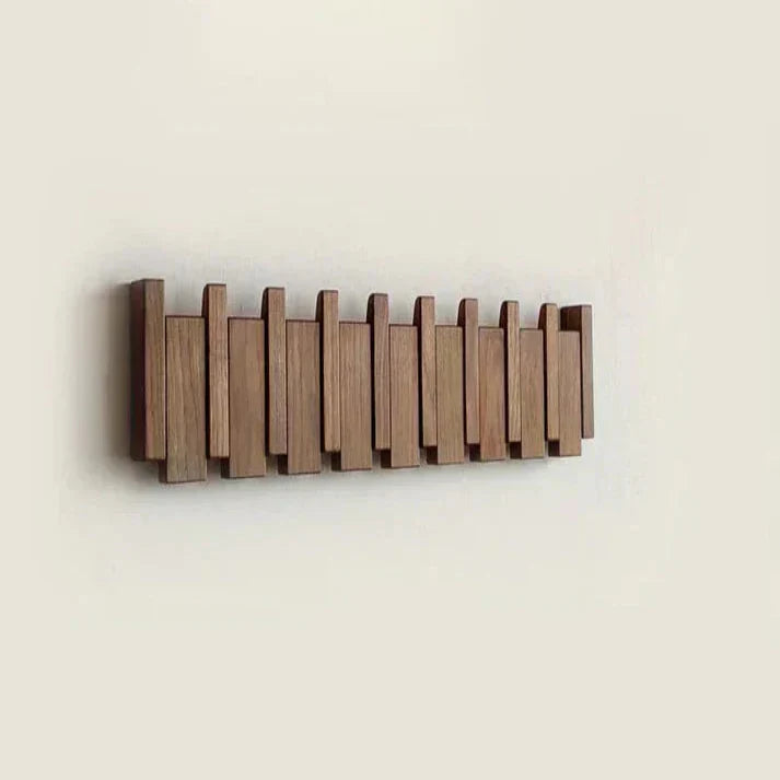 "Houten kapstok met pianotoets design, gemaakt van duurzaam walnoot- en beukenhout, voorzien van meerdere haken."