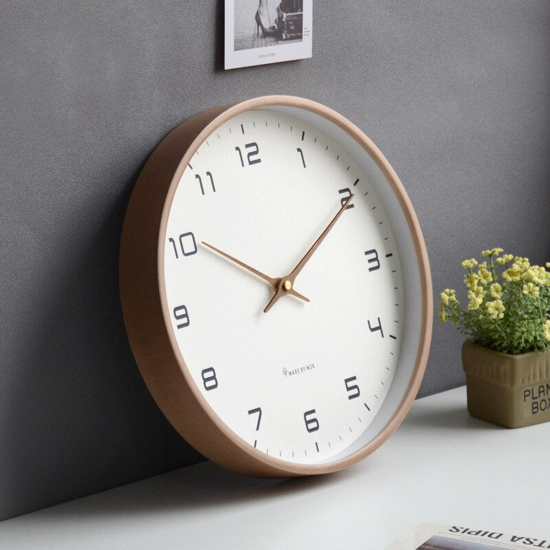 Dichtbij houten wandklok, toont natuurlijke houtnerf en stille beweging. Modern Scandinavisch design.