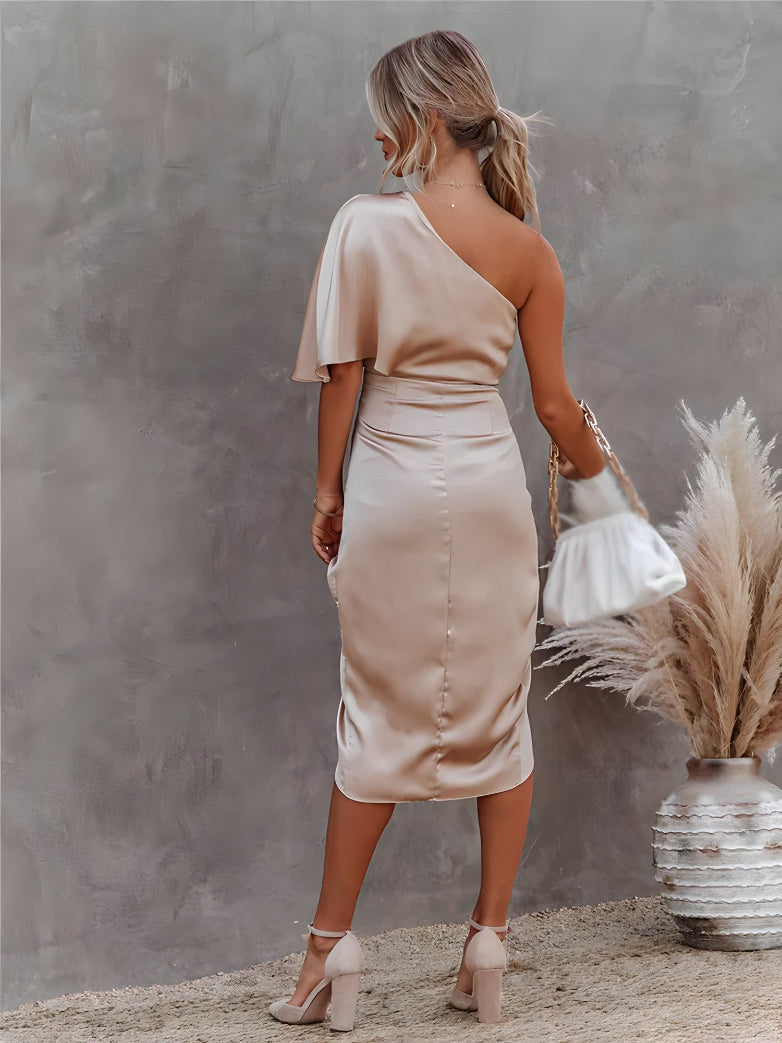Vrolijke vrouw draagt een comfortabele asymmetrische off-shoulder feestjurk.