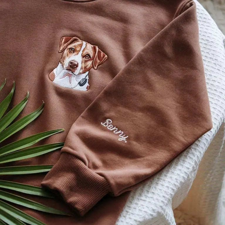 Close-up van het verfijnde borduurwerk op de gepersonaliseerde hoodie, ter ere van je overleden huisdier.
