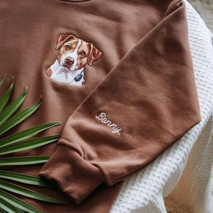Close-up van het verfijnde borduurwerk op de gepersonaliseerde hoodie, ter ere van je overleden huisdier.