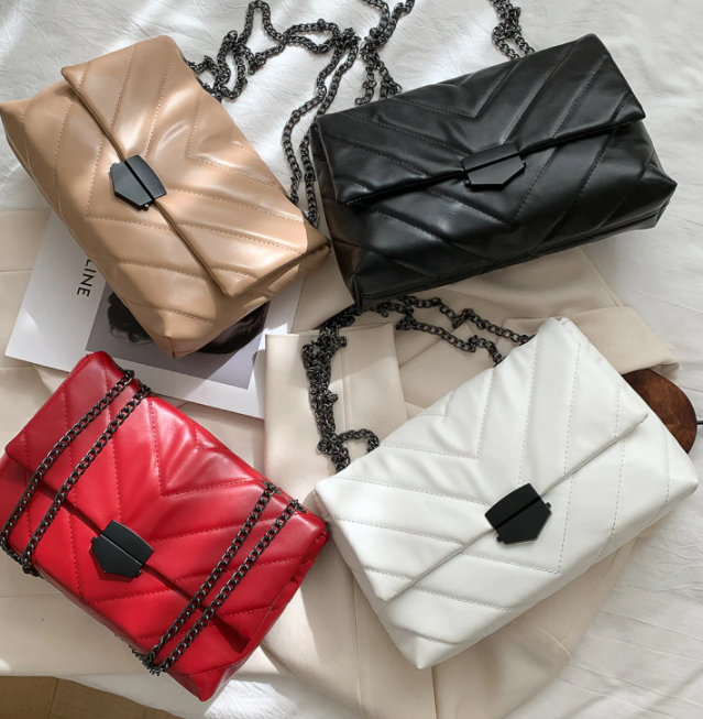 Detail van de gouden ketting schouderband op een elegante PU leer crossbody tas.
