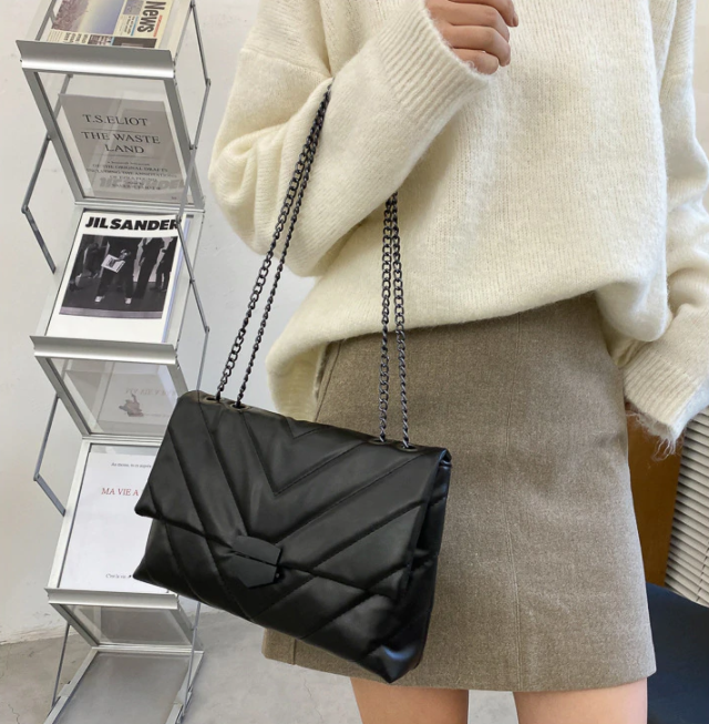 Trendy vrouw draagt een PU leer crossbody tas met ketting, ideaal voor dagelijks gebruik.