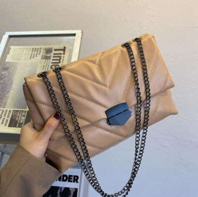 Mode accessoire: een verfijnde PU leer dames crossbody tas met opvallende ketting.