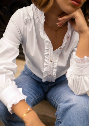 Elegante witte damesblouse Isalie met chique gouden knopen, perfect voor zakelijke en modieuze gelegenheden.