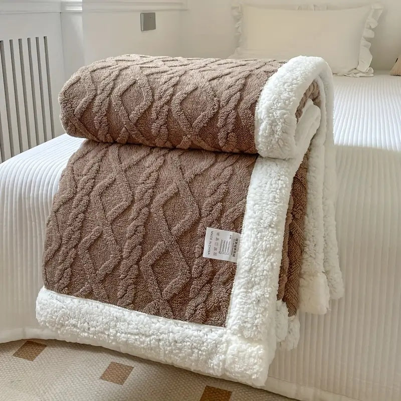 Warme sherpa deken met boek en thee; creëert een cosy en comfortabele sfeer, ideaal als zachte woondeken of bankplaid.