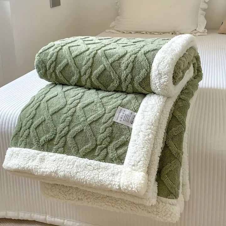 Persoon geniet van de warmte en zachtheid van een knusse sherpa deken; ultiem comfort voor ontspanning thuis.