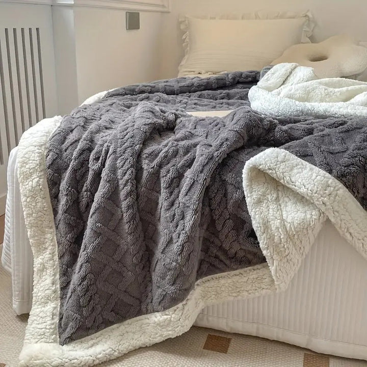 Comfortabele sherpa deken, elegant over een bank gedrapeerd; perfecte warme plaid voor een knus interieur en cosy momenten.