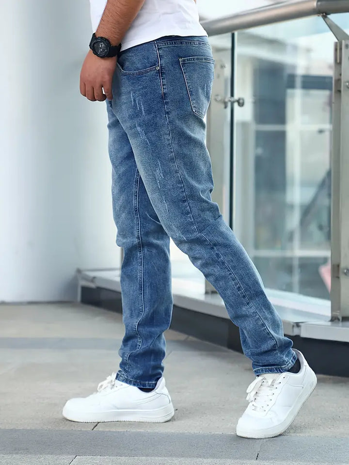 Detailopname van een comfortabele slim fit herenjeans in donkerblauw, accentueert de moderne pasvorm.
