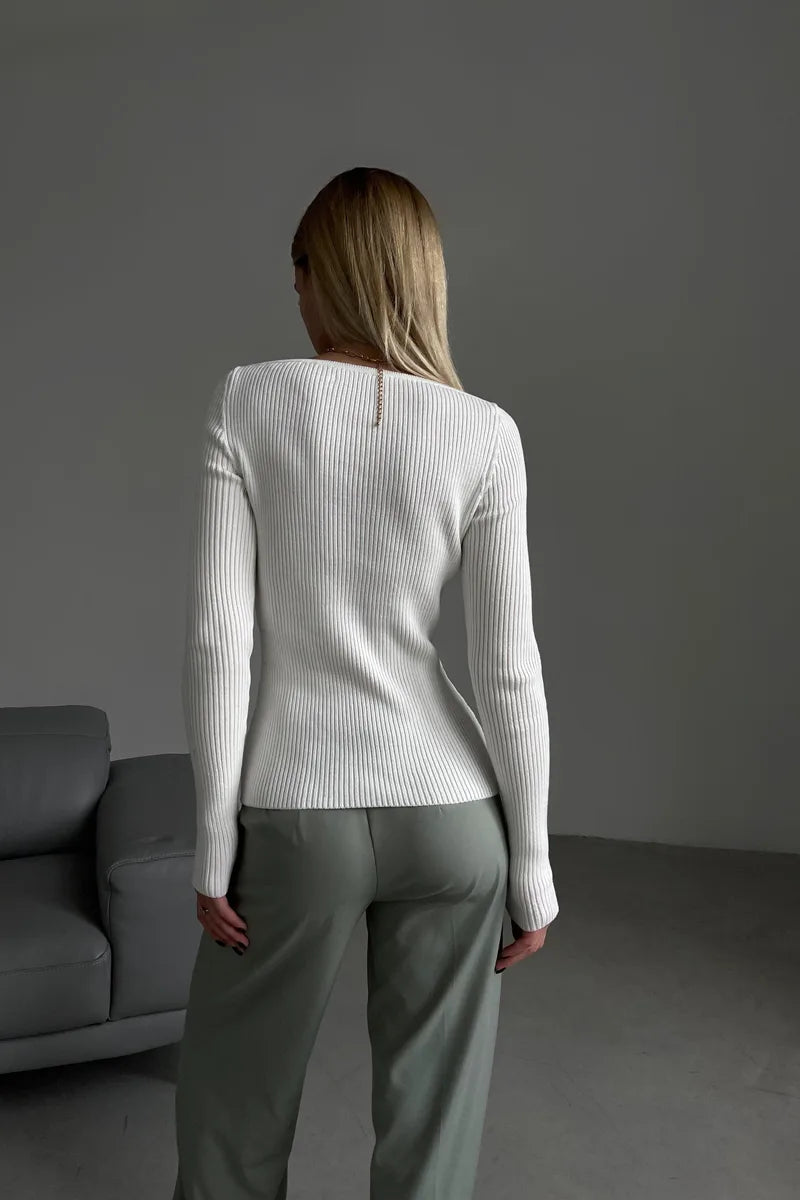 Detailopname van de fijne ribstof van een comfortabele off shoulder damestrui, perfect voor de herfst.