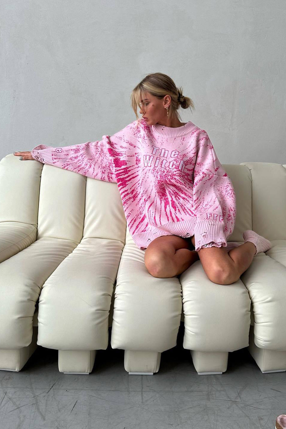 Zwarte oversized damestrui met coole grafische print en gescheurde details. Comfortabel en veelzijdig.