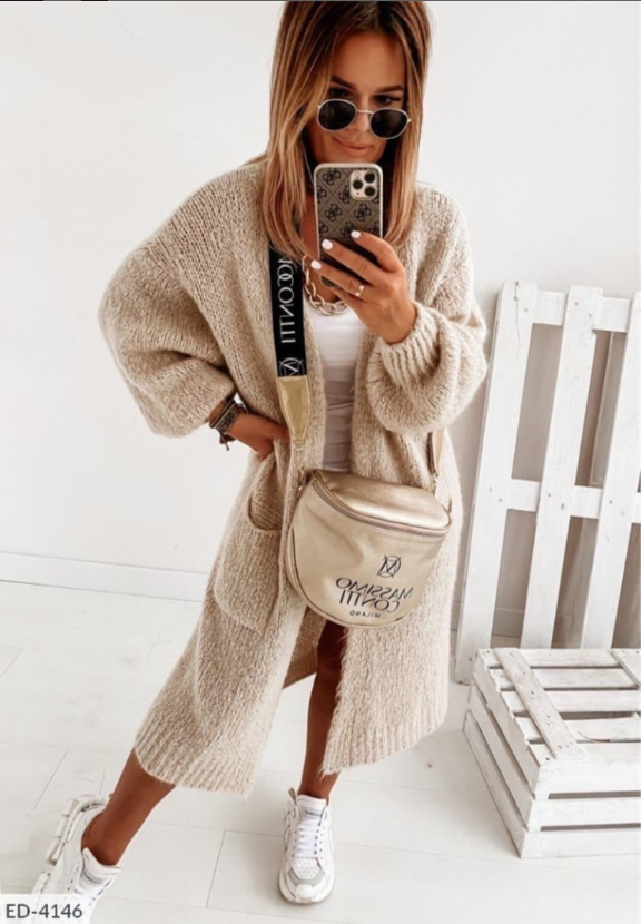 Modieus lang gebreid damesvest met stijlvolle zakken, perfect voor een elegante herfstoutfit.