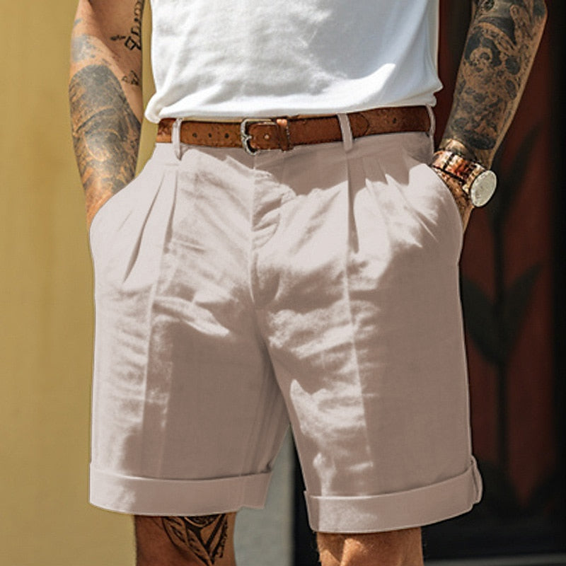 Detail van beige heren geplooide shorts met omslagzoom, toont de tailleband en vouwen voor een nette look.