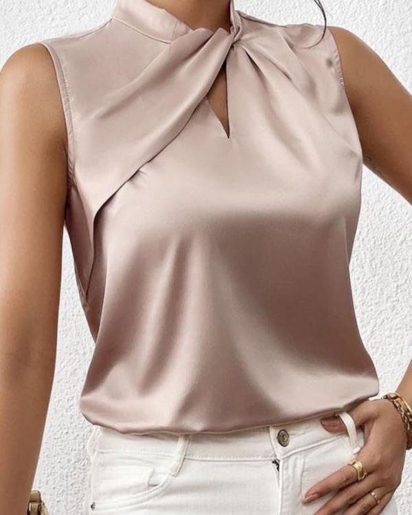 Gouden mouwloze damesblouse met elegante gedraaide hals. Chique en modieuze top, ideaal voor zomer of speciale momenten.
