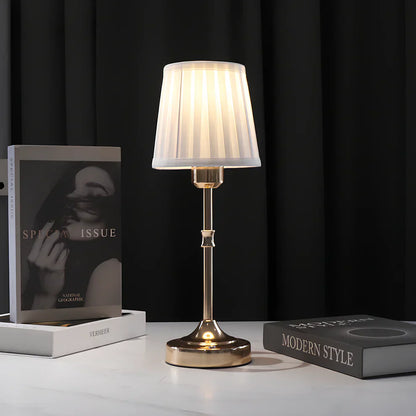 "Klassieke tafellamp met metalen frame en stoffen kap in een interieur, draadloos met drie lichtstanden."