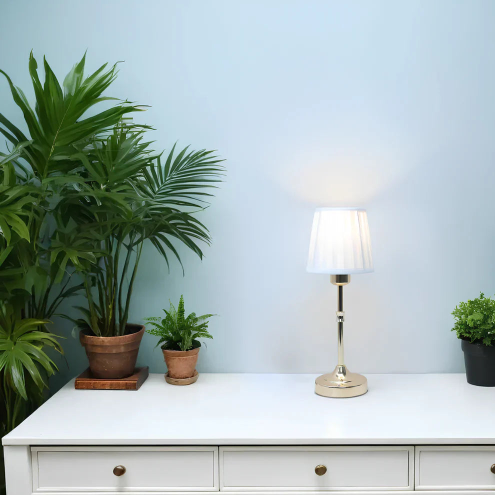 "Klassieke tafellamp met metalen frame en stoffen kap in een interieur, draadloos met drie lichtstanden."