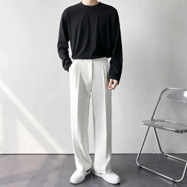Model toont witte herenpantalon met wijde pijpen, comfortabel en stijlvol, voor een veelzijdige casual look.