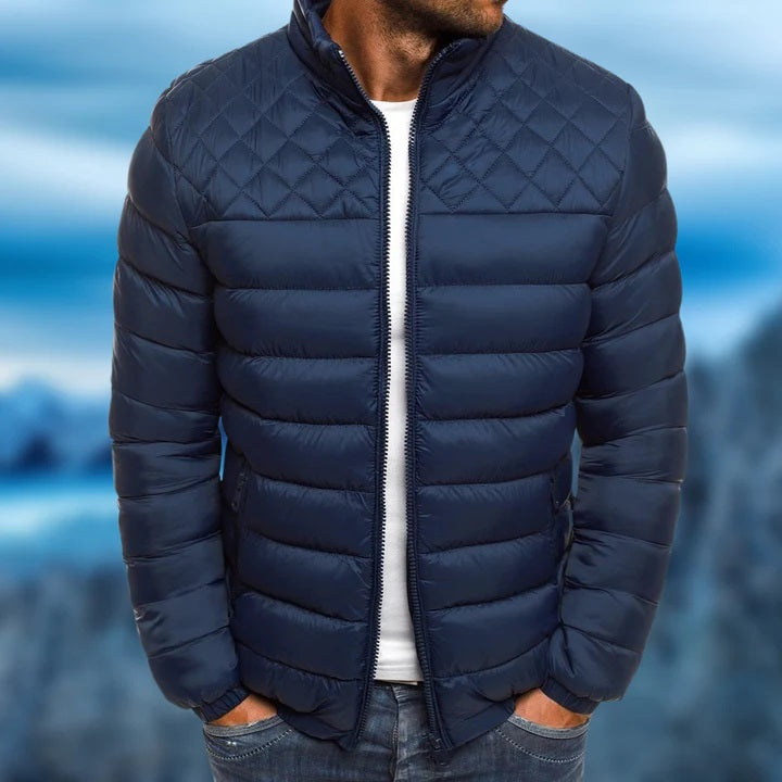 Donkerblauwe heren gewatteerde jas, winddicht & waterafstotend. Ideaal voor winter en tussenseizoen outdoor activiteiten.