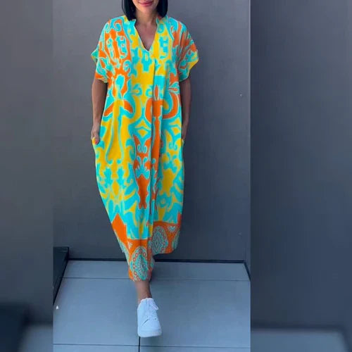 "Levendige bedrukte kaftan maxi jurk met tropisch dessin, V-hals en korte mouwen, ideaal voor zomerse dagen en avonden."