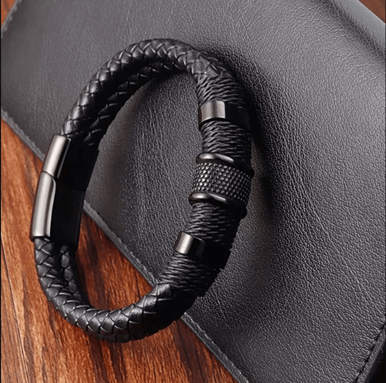 Close-up van textuur geweven leren herenarmband, met RVS magnetische sluiting, robuust sieraad.